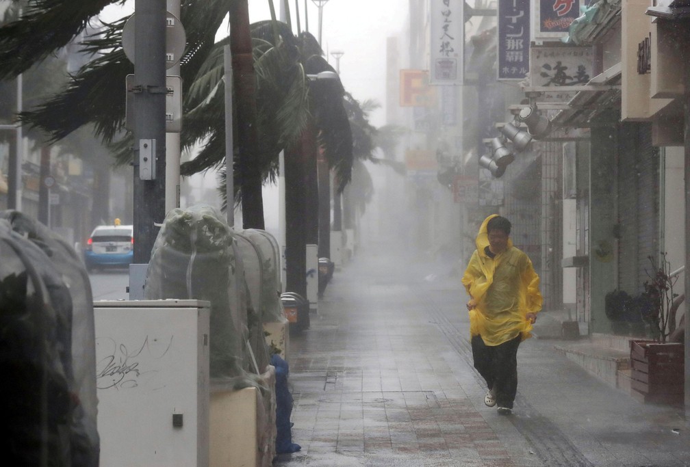 Homem caminha sob forte chuva e ventos provocados pela passagem do tufão Trami por Naha, na ilha de Okinawa, neste sábado (29) — Foto: Kyodo / via REUTERS 