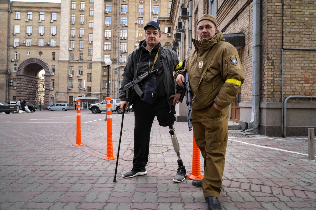 26 de fevereiro - Civis armados posam para uma foto enquanto patrulhavam uma rua vazia devido ao toque de recolher em Kiev, na Ucrânia, neste domingo (27) — Foto: Efrem Lukatsky/AP