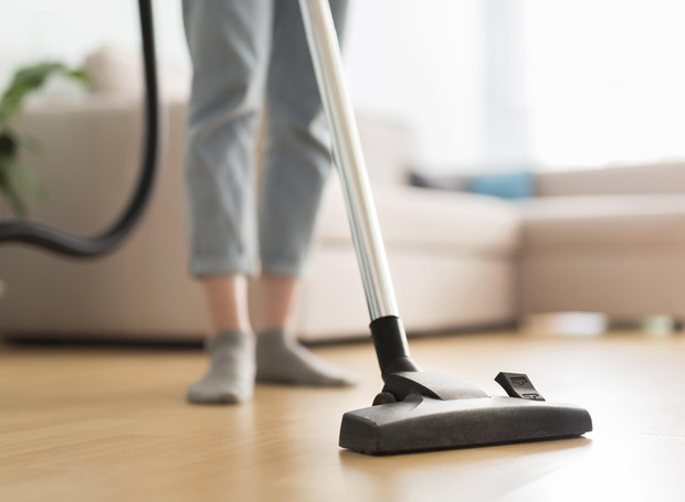 Limpando o chão com o aspirador de pó (Foto: Freepik/Creative Commons)