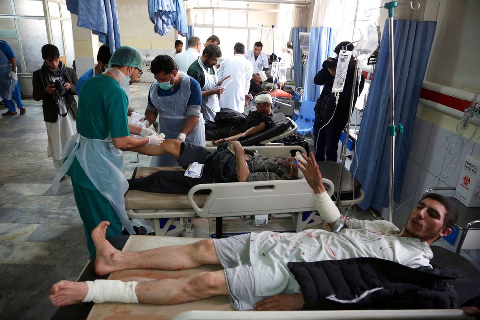 Feridos recebem atendimento após ataque neste sábado (27) em Cabul, no Afeganistão  (Foto: Rahmat Gul/ AP)