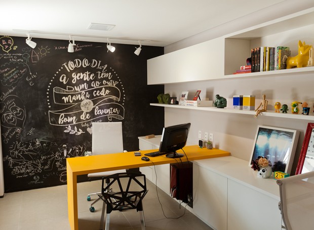 Escritório | O ambiente mais divertido do lar é o escritório. A mesa de nanoglass amarela da Carioca Granitos dá um toque especial ao cômodo, junto com a parede de lousa. Prateleiras planejadas pela Stanza Móveis (Foto: Maurício Pokemon/Divulgação )
