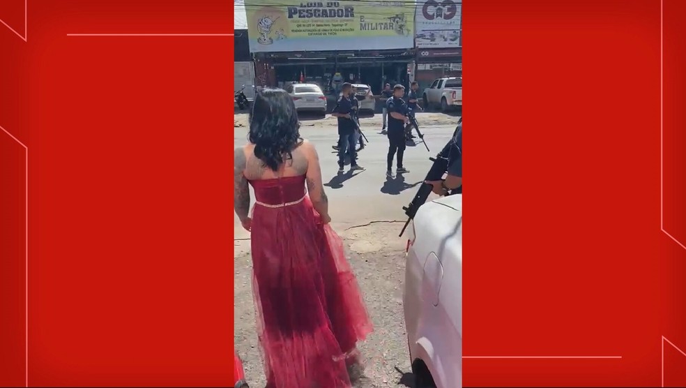 Homens armados param trânsito para que mulher de vermelho atravesse pista, no DF — Foto: Reprodução