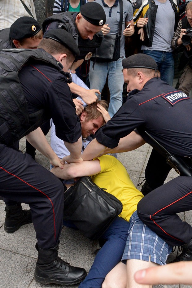 Polícia tenta separar um homem favorável à nova lei (de camiseta azul) e um ativista dos direitos LGBT (de amarelo) que se confrontaram em frente ao Parlamento em Moscou (Foto: Kirill Kudryavtsev/AFP)