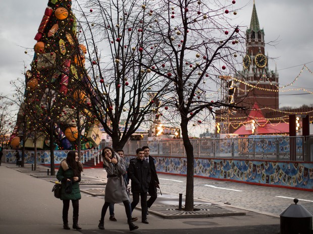 Turistas aproveitam o clima ameno na Praça Vermelha, em Moscou, em foto do dia 23 de dezembro. As temperaturas chegaram a mais de 5º C  no Natal este ano, bem acima do comum para esta época  (Foto: AP Photo/Alexander Zemlianichenko)