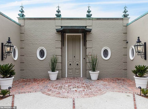 A entrada é mais discreta com as portas pintadas na mesma cor que as paredes (Foto: MLS/ Reprodução)