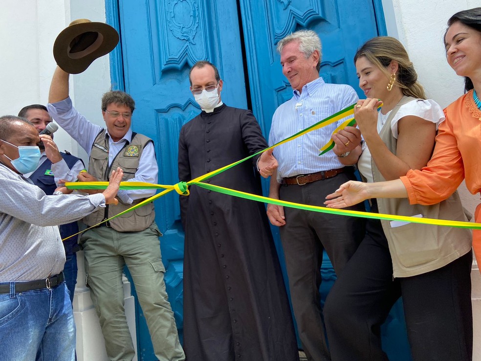 Ministro do Turismo, Gilson Machado (de chapéu na mão), ao lado do pároco da Igreja Nossa Senhora Mãe dos Homens e do senador Fernando Collor durante reinauguração em Coqueiro Seco, Alagoas — Foto: Michelle Farias/g1