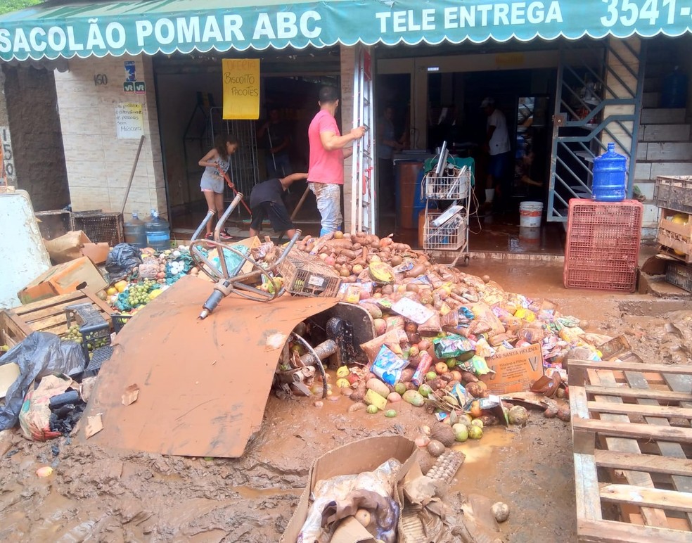 Moradores limpam comércios e casas invadidos pela água — Foto: Patrícia Fiúza / TV Globo