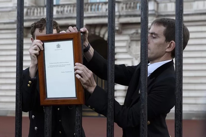 A notícia da morte da rainha foi afixada ao portão do palácio de Buckingham por funcionários da casa real (Foto: TOM PILSTON via BBC)