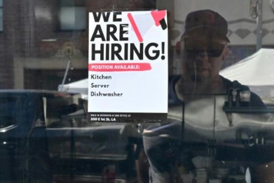 Homem observa um cartaz com oferta de emprego em um restaurante em Los Angeles