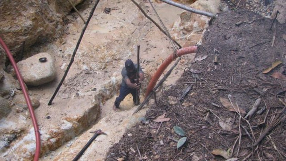 Garimpo de barrancos. É quando garimpeiros quebram a terra com a força da água. A lama é escoada para uma peneira com mercúrio e o ouro fica grudado no mercúrio. O rejeito é jogado na floresta — Foto: JAKELINE PEREIRA