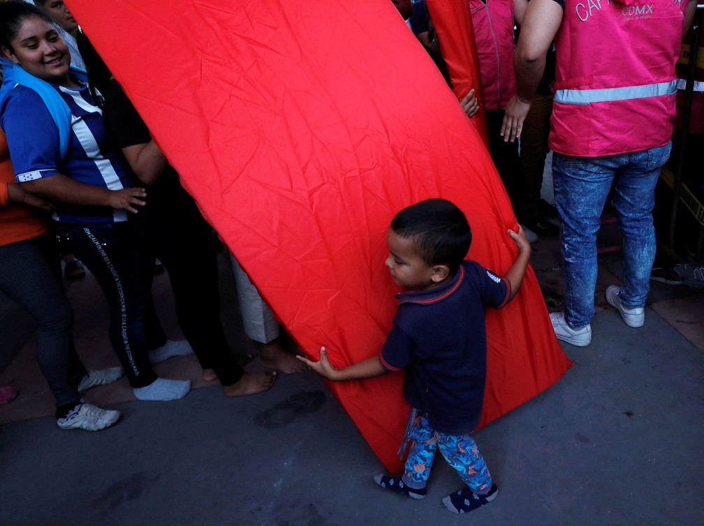 Criança migrante recebe colchão em abrigo na Cidade do México — Foto: Henry Romero/Reuters