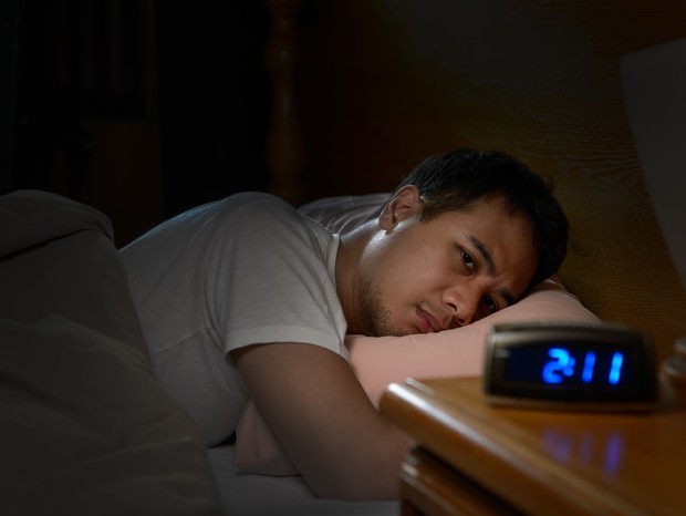 Depressed man suffering from insomnia lying in bed (Foto: Getty Images/iStockphoto)