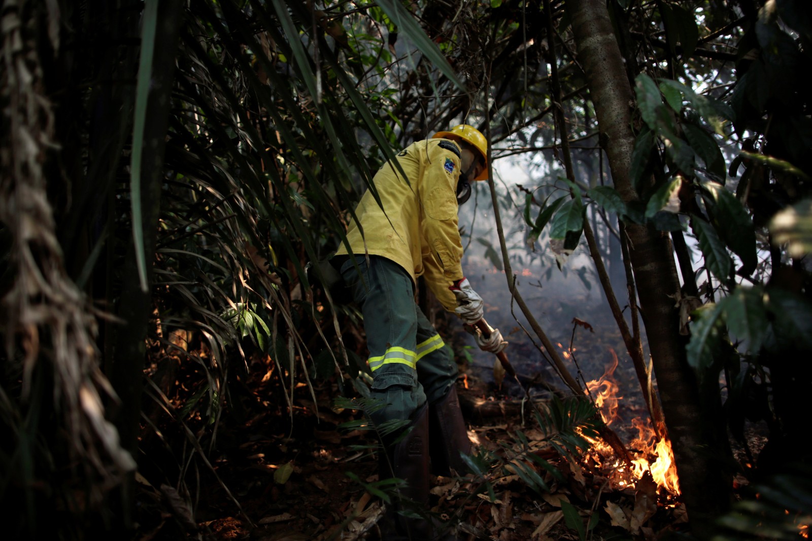 Membro da brigada de incêndio do Instituto Brasileiro do Meio Ambiente e dos Recursos Naturais Renováveis (Ibama) tenta controlar um incêndio em uma área da floresta amazônica, em Apuí, no AmazonasREUTERS