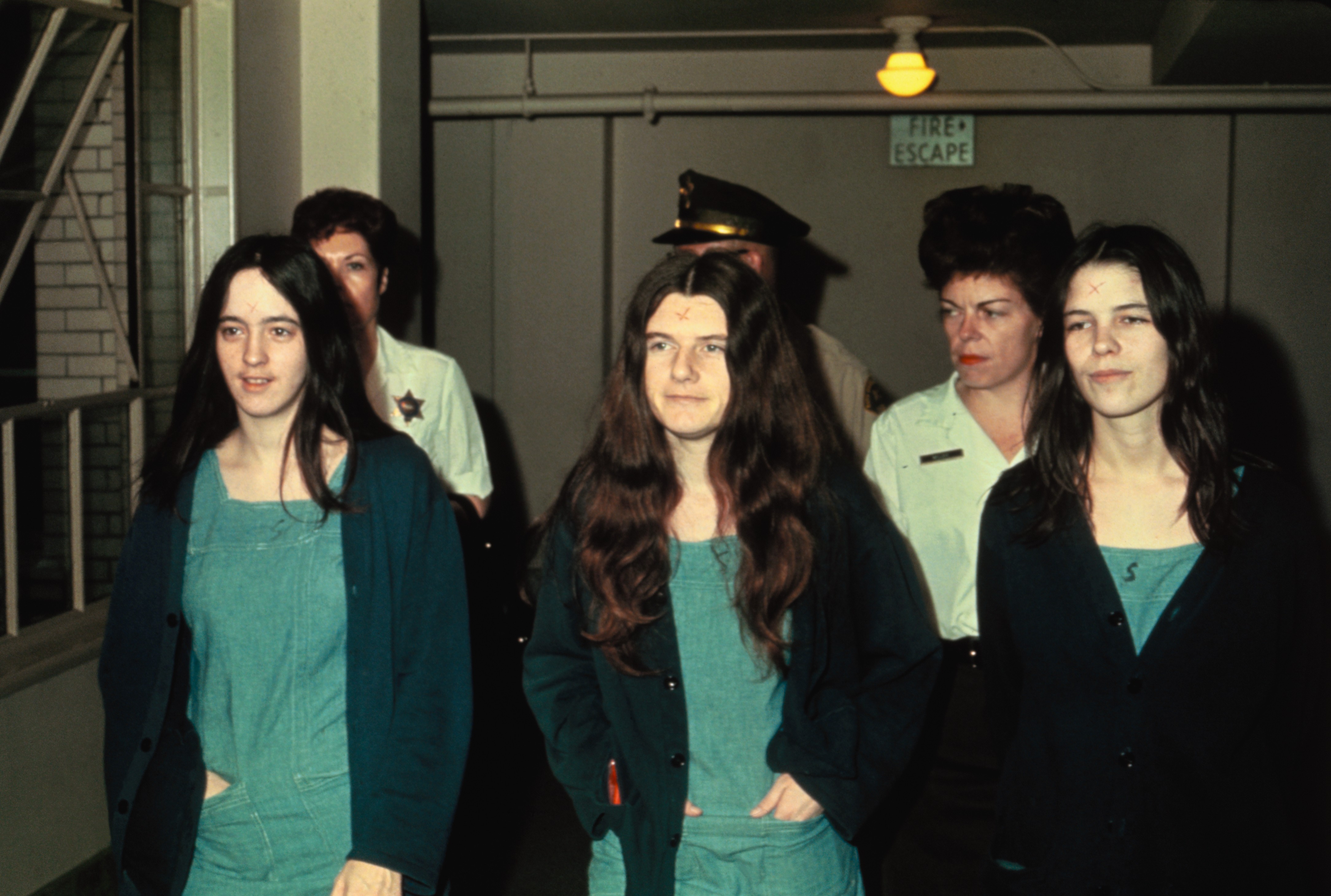 Susan Atkins, Patricia Krenwinkle e Leslie van Houton acompanhadas por policiais enquanto eram levadas para julgamento (Foto: Getty Images)