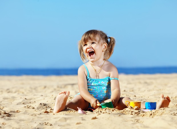 Criança brincando na areia da praia (Foto: Shutterstock)