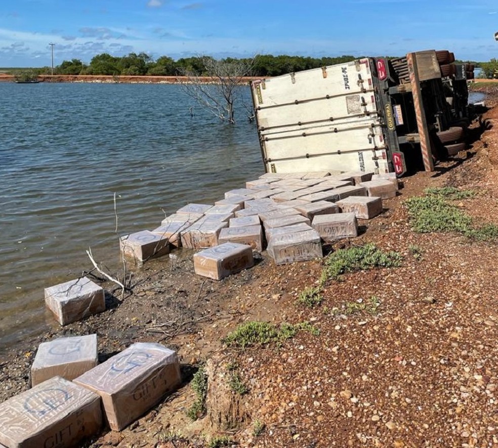 Carga de cigarros contrabandeados e carreta tombada foram encontradas às margens de rio em Macau — Foto: Polícia Civil/Divulgação
