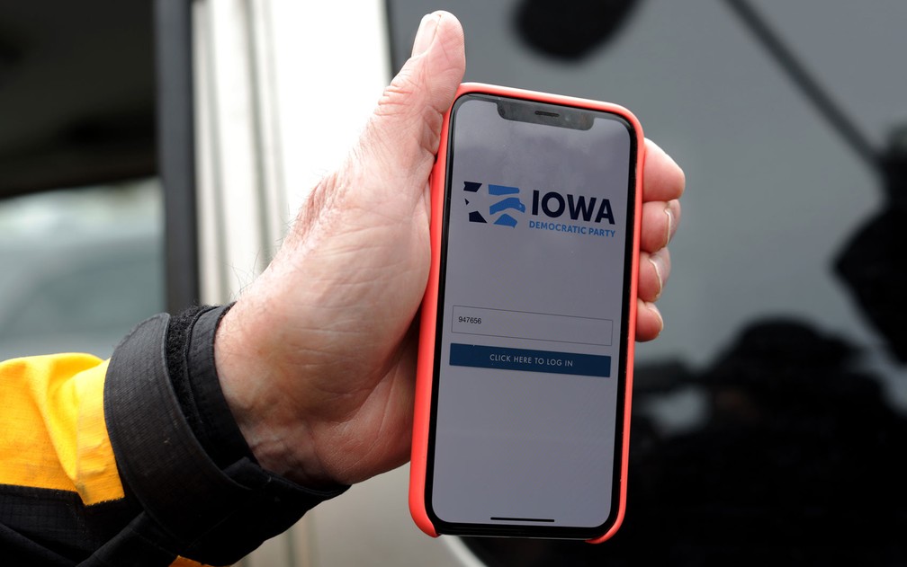 Carl Voss, vereador de Des Moines e responsável por um dos locais de votação no caucus, mostra o aplicativo do Partido Democrata de Iowa, em foto de terça-feira (4) — Foto: Alex Wong/Getty Images/AFP