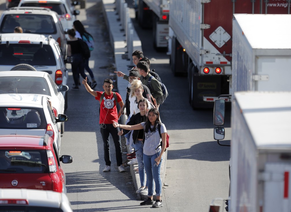 Pedestres pedem carona para entrar nos EUA pela fronteira com o MÃ©xico â Foto: Gerald Herbert/Reuters