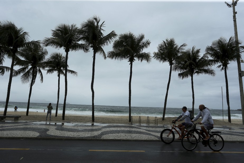 Ciclistas enfrentam a chuva na orla da Zona Sul
