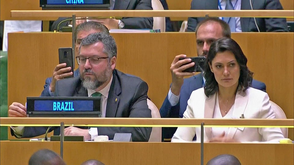 O chanceler Ernesto Araújo acompanha o discurso do presidente ao lado da primeira-dama, Michelle Bolsonaro, e do deputado Eduardo Bolsonaro — Foto: Reprodução