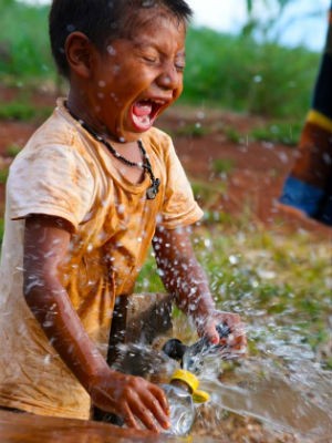 Menino indígena se diverte com a água. (Foto: Daniel Jaeger Vendruscolo / Arquivo pessoal)
