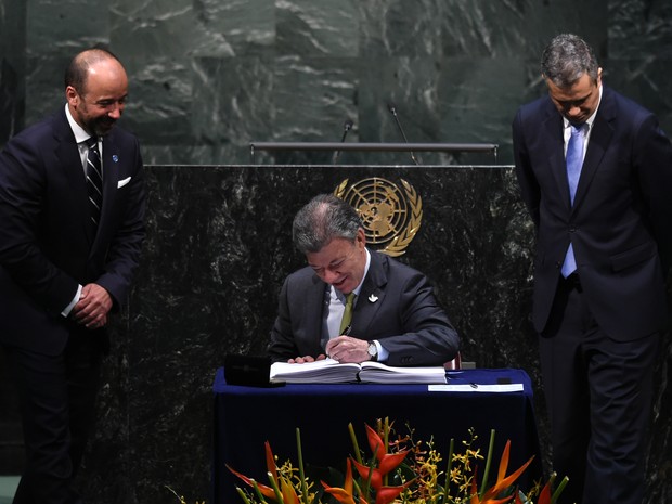 O presidente da Colômbia, Juan Manuel Santos, assina acordo de Paris durante encontro da ONU (Foto: Jewel Samad/AFP)