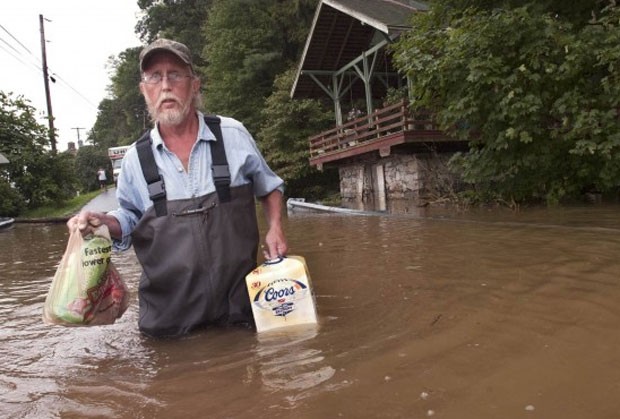 Em setembro de 2011, o americano Mike Ingolls foi flagrado enfrentando uma rua inundada enquato levava para sua casa em Hellam Township, no estado da Pensilvânia (EUA), uma caixa de cerveja (Foto: AP)