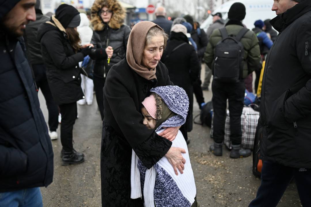 Uma mulher abraça uma menina enquanto refugiados da Ucrânia esperam por transporte na fronteira entre a Moldávia e a Ucrânia, em 1º de março de 2022