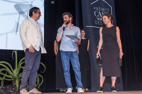 Artur Lescher entrega o prêmio da categoria complementos para Gerson de Oliveira e Luciana Martins, da Ovo 