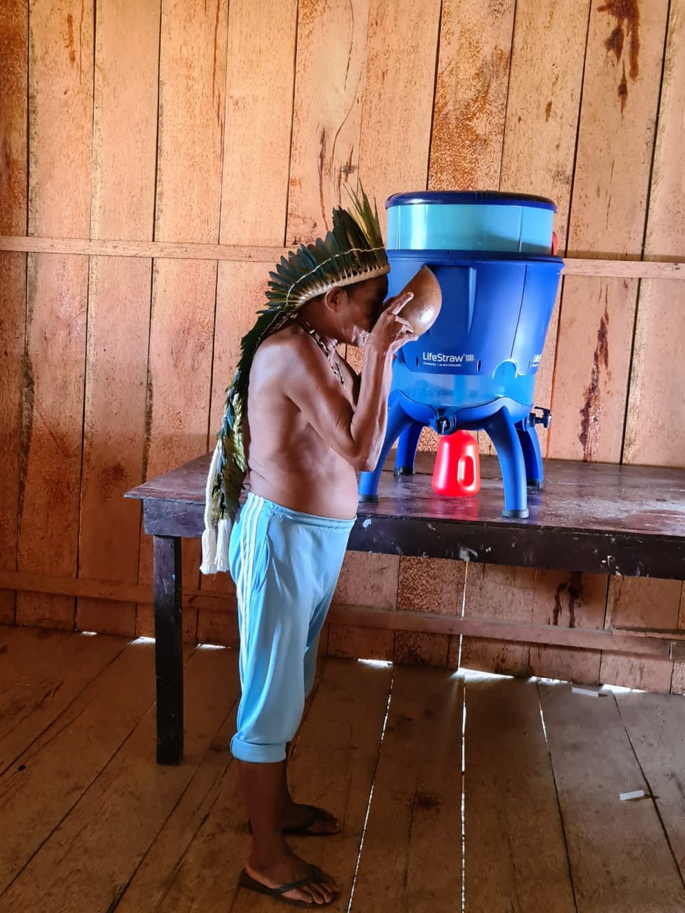 Indígena bebe água potável depois da instalação de filtros na aldeia — Foto: Paulo Desana