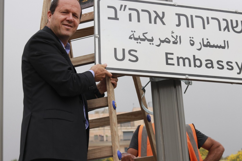 Prefeito de Jerusalém, Nir Barkat, posa para foto ao lado de placa que indica a embaixada americana na cidade (Foto: Prefeitura de Jerusalém via AP)