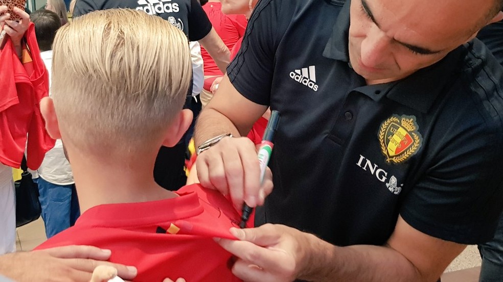Roberto Martínez assina a camisa de um torcedor no aeroporto (Foto: Divulgação / Red Devils)