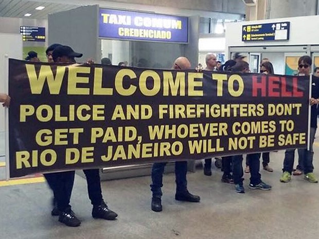 Policiais levaram faixa para o galeão com os dizeres, em inglês: 'Bem-vindo ao inferno' (Foto: Reprodução/Globo)