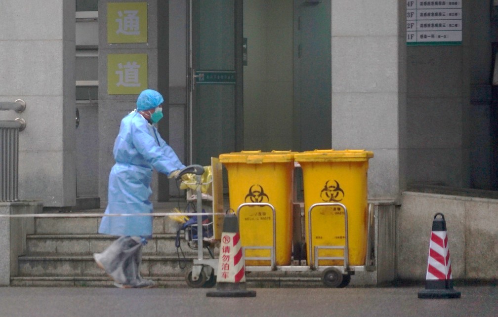 Funcionário remove lixo hospitalar de centro médico de Wuhan, epicentro da epidemia de coronavírus, na China  Foto: AP Photo/Dake Kang