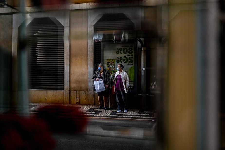 Duas mulheres esperam pelo ônibus no centro de Lisboa