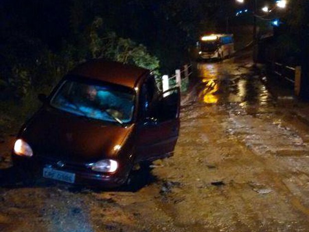 Carro caiu em buraco que se abriu em rua depois de uma hora e meia de chuva em Lavras, MG (Foto: Jornal de Lavras)