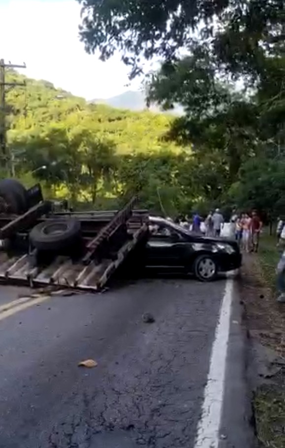 Duas pessoas ficam feridas após caminhão tombar em cima de carro na Rio-Santos em São Sebastião