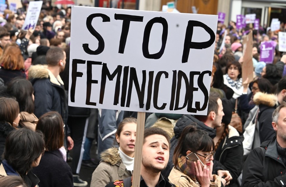 Jovem segura placa contra feminicídio em protesto na cidade de Paris neste sábado (23) — Foto: DOMINIQUE FAGET / AFP
