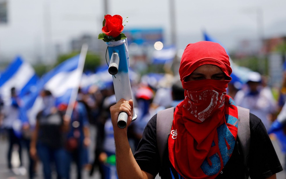 Manifestante exibe morteiro caseiro com uma flor durante marcha para exigir libertação de presos políticos em Manágua, na Nicarágua, em 21 de julho (Foto: Reuters/Oswaldo Rivas)