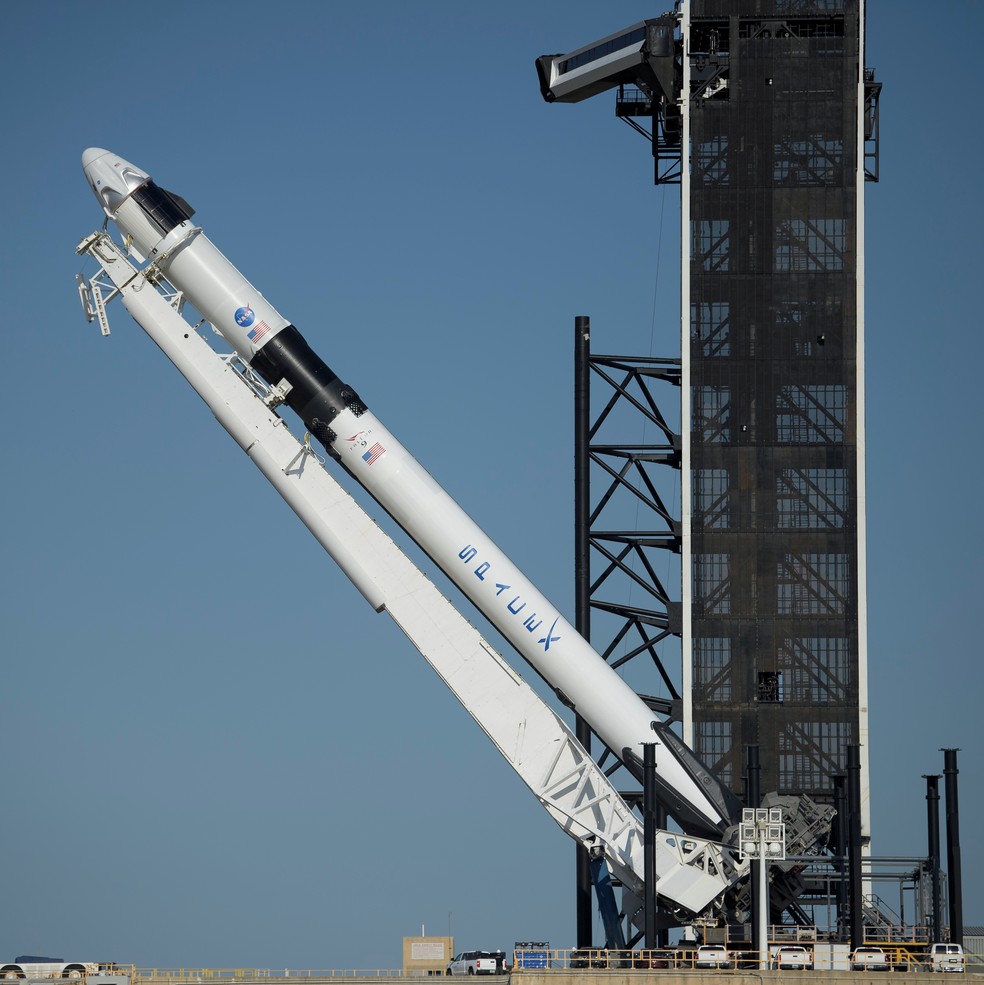 O foguete SpaceX Falcon 9 com a espaçonave Crew Dragon é colocado na posição vertical na plataforma de lançamento no Centro Espacial Kennedy no Cabo Canaveral, na Florida (EUA), durante os preparativos para a missão Demo-2 na Estação Espacial Internacional na quinta-feira (21) — Foto: Bill Ingalls/NASA via Reuters
