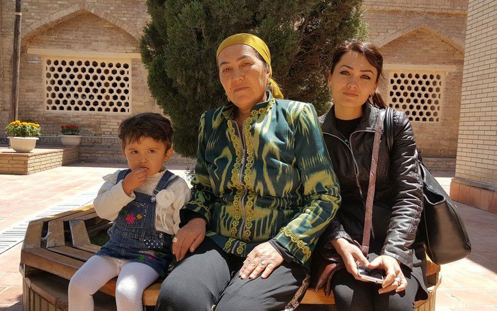 Dilrabo (centro) viajou com a filha e a neta para rezar no túmulo de Daniyar — Foto: BBC