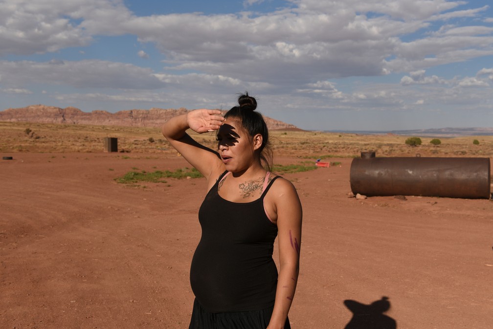 Summer Weeks, de 23 anos, que está grávida, protege seus olhos do sol da propriedade de sua família uma área remota da Bodaway Chapter, na reserva Navajo — Foto: Stephanie Keith/Reuters