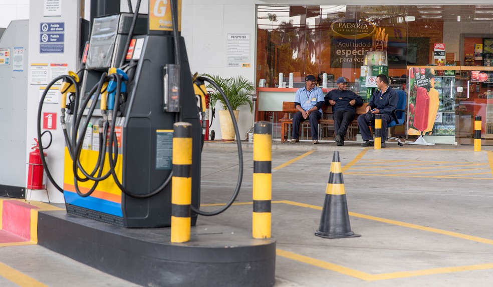 Funcionários de um posto de combustíveis na zona sul de São Paulo conversam em um banco em 2018 — Foto: Marcelo Brandt/G1