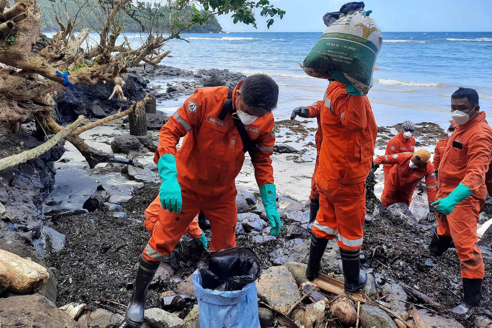 Guarda Costeira das Filipinas e voluntários coletam detritos de derramamento de óleo na costa de Pola  — Foto: AFP