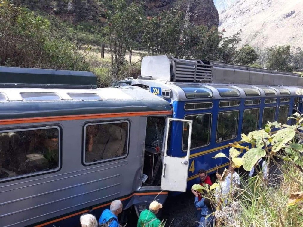 Passageiros observam trens que colidiram nesta terça-feira (31) em estrada que dá acesso a Machu Picchu, no Peru (Foto: Andina News Agency via AP)