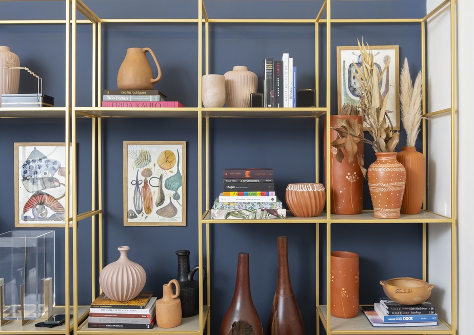 Objetos decorativos, quadros e livros são excelentes opções para decorar estantes