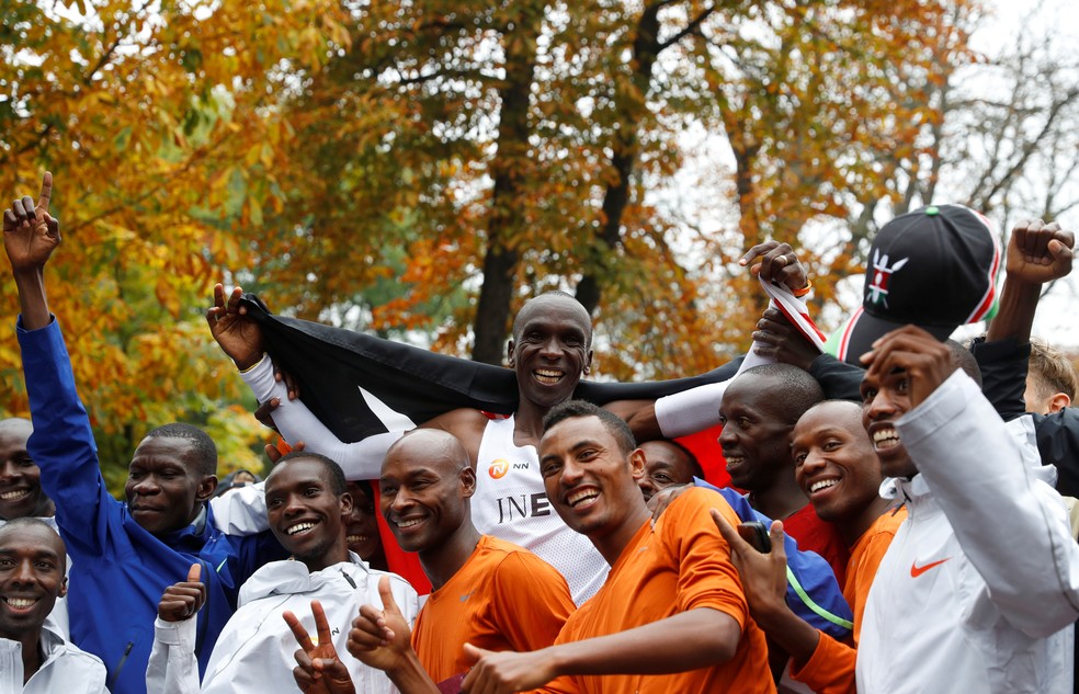 Atletas das equipes de apoio comemoram o mitológico Eliud Kipchoge  — Foto: Reuters