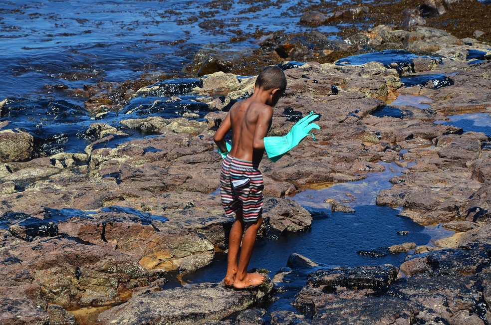 Menino em meio ao óleo que se espalhou pelo litoral de Pernambuco — Foto: Marcela Cintra/Arquivo Pessoal