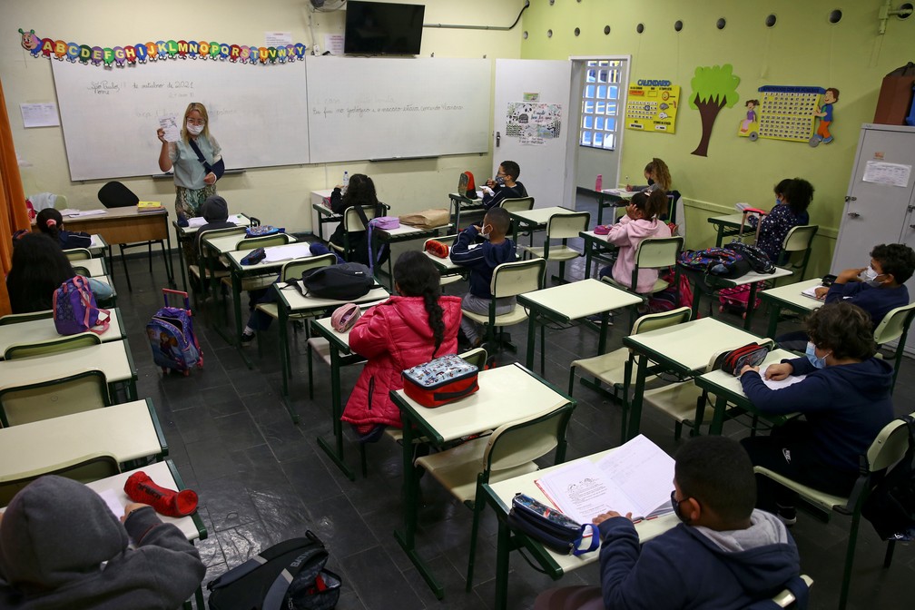 Alunos assistem a aula no primeiro dia de retorno escolar 100% presencial na pandemia na segunda-feira (18). — Foto: Carla Carniel/Reuters