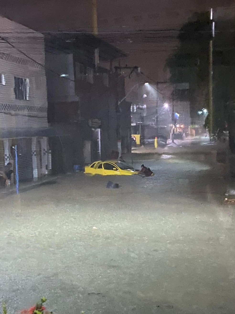 Carro fica quase submerso devido a chuva no bairro Mumbuca, em Maricá. Moradores tentam se salvar — Foto: Redes sociais 